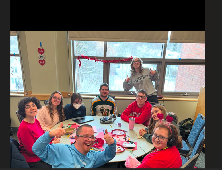 Chloe with her team sitting around a table
