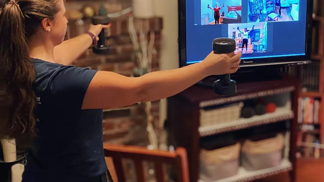 A fitness instructor leads a virtual exercise class.