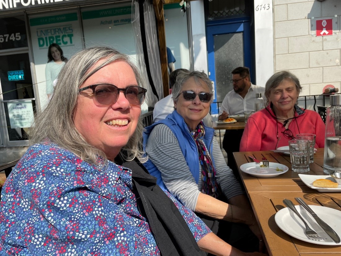 OLLI members smiling for the camera while seated in an outdoor setting