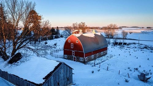 A red barn against a snowy backdrop photo by Tom Fesk/Pexels