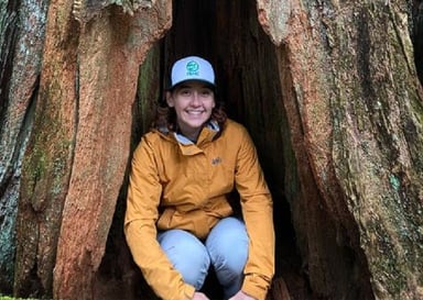 Emma Conti inside a large tree trunk